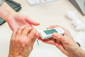 Person having their blood glucose level checked with a portable glucometer.