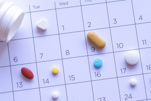 A calendar displaying various pills arranged on its surface